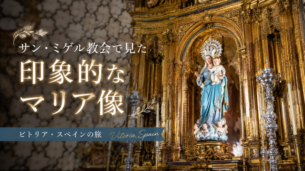 スペイン・ビトリアのサン・ミゲル教会で、金色に輝く豪華な祭壇に安置された、青い衣をまとい幼子イエスを抱く聖母マリア像を描いた見出し画像。「サン・ミゲル教会で見た印象的なマリア像」と書かれている。