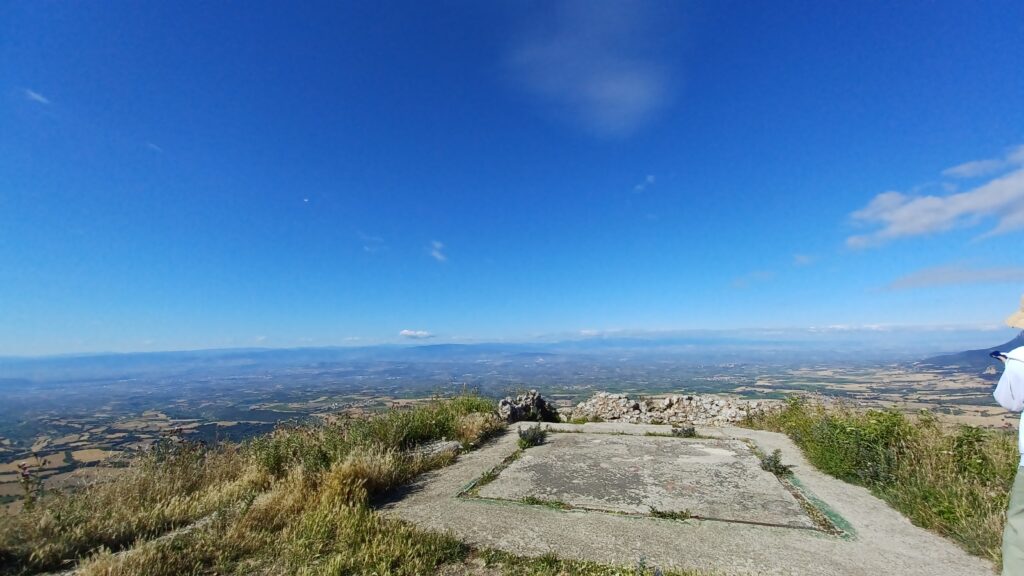 スペイン・バスク地方の山頂展望スポットから見渡す山々と農村風景。晴れた青空の下に広がる雄大な景色。