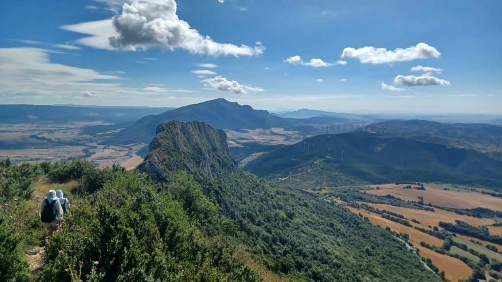 スペイン・バスク地方の山頂から見渡す山々と農村風景。晴れた青空の下に広がる雄大な景色。