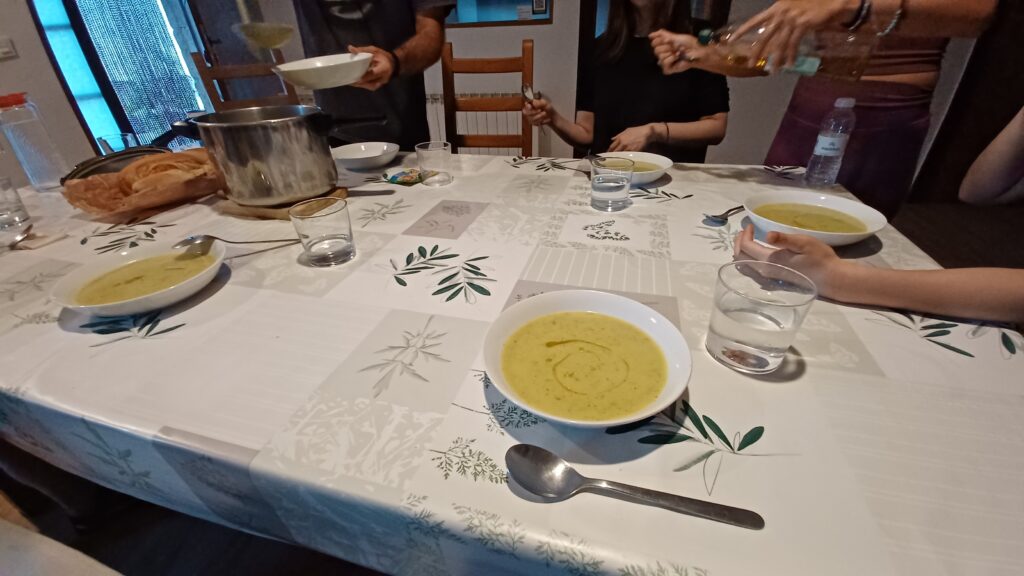 スペインの食卓を囲んで取り分けられる夕食のスープ